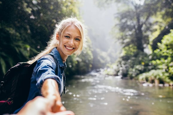 Woman offering hand on river